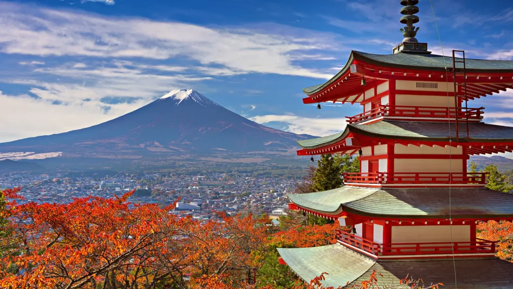 Pagode Chureito de cinco andares, vermelho, com o monte Fuji nevado ao fundo e árvores de folhas vermelhas de outono em Fujiyoshida, no Japão
